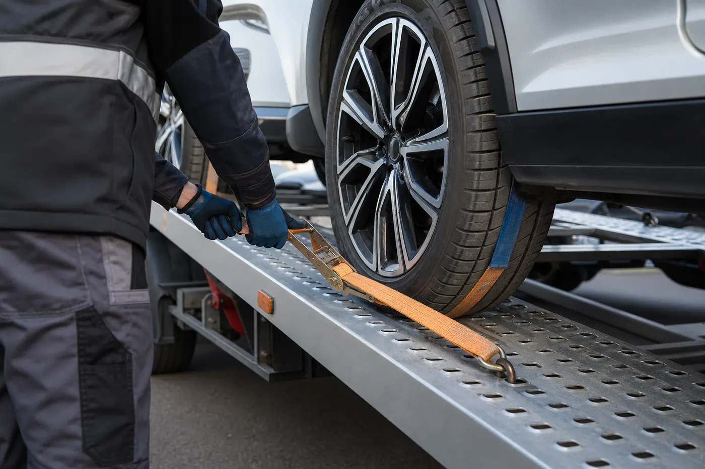 Vehicle transporter securing a car with wheel straps