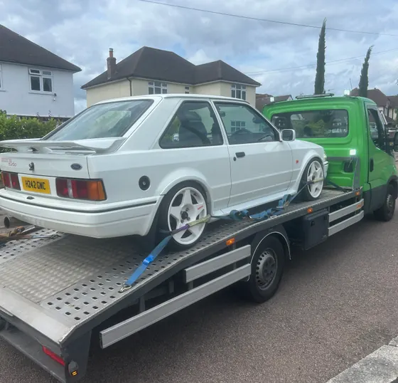 TLRec transporting a white Ford on a recovery truck