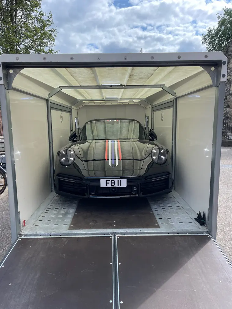 Porsche inside an enclosed vehicle trailer