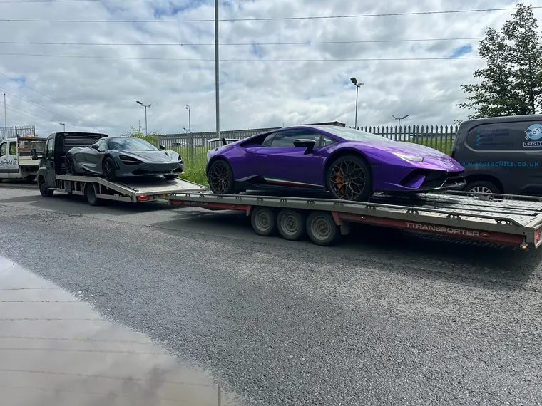 Supercars secured on a vehicle transporter and trailer